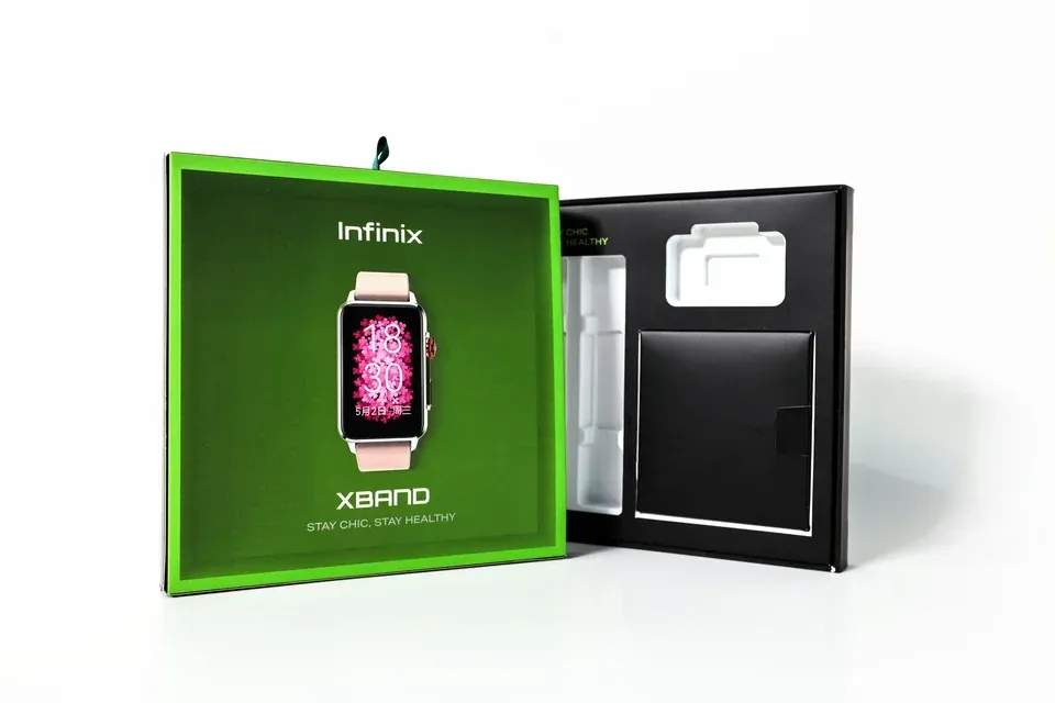An Infinix smartwatch box beside its black inner tray